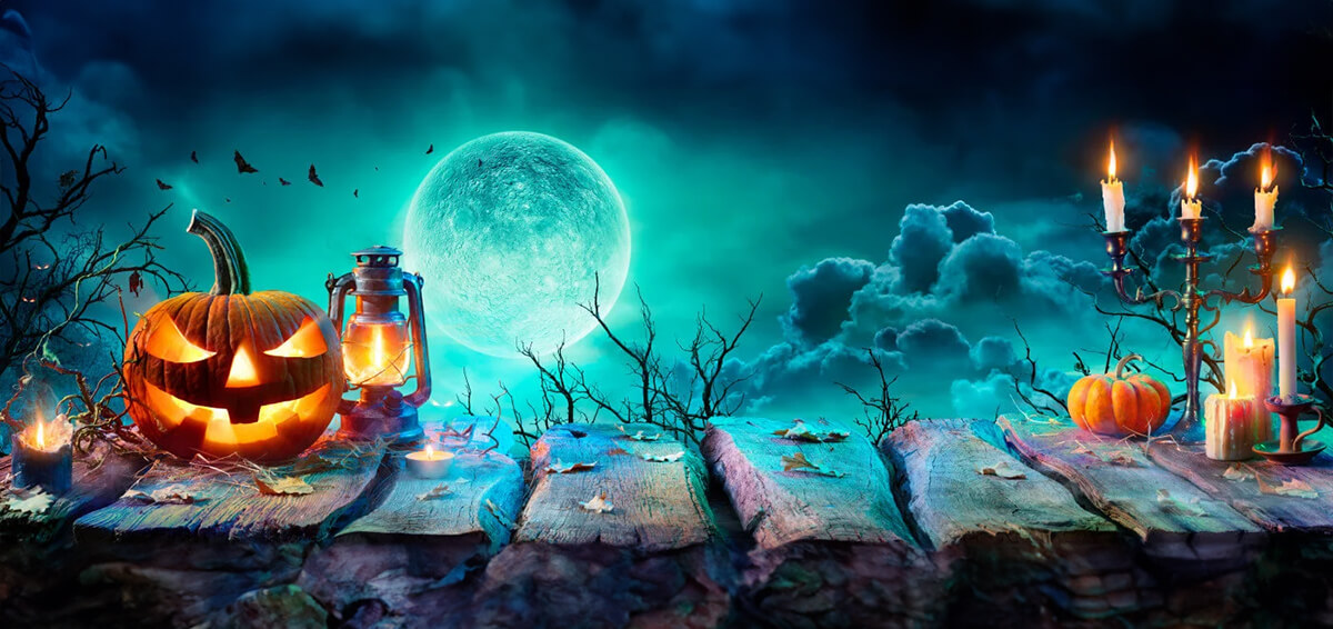A spooky night sky with various Halloween objects including pumpkins and candles