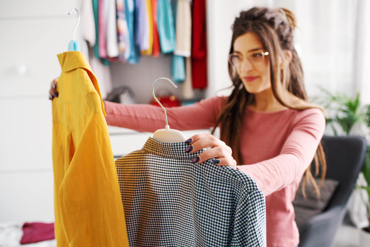 Woman looking at two different shirts