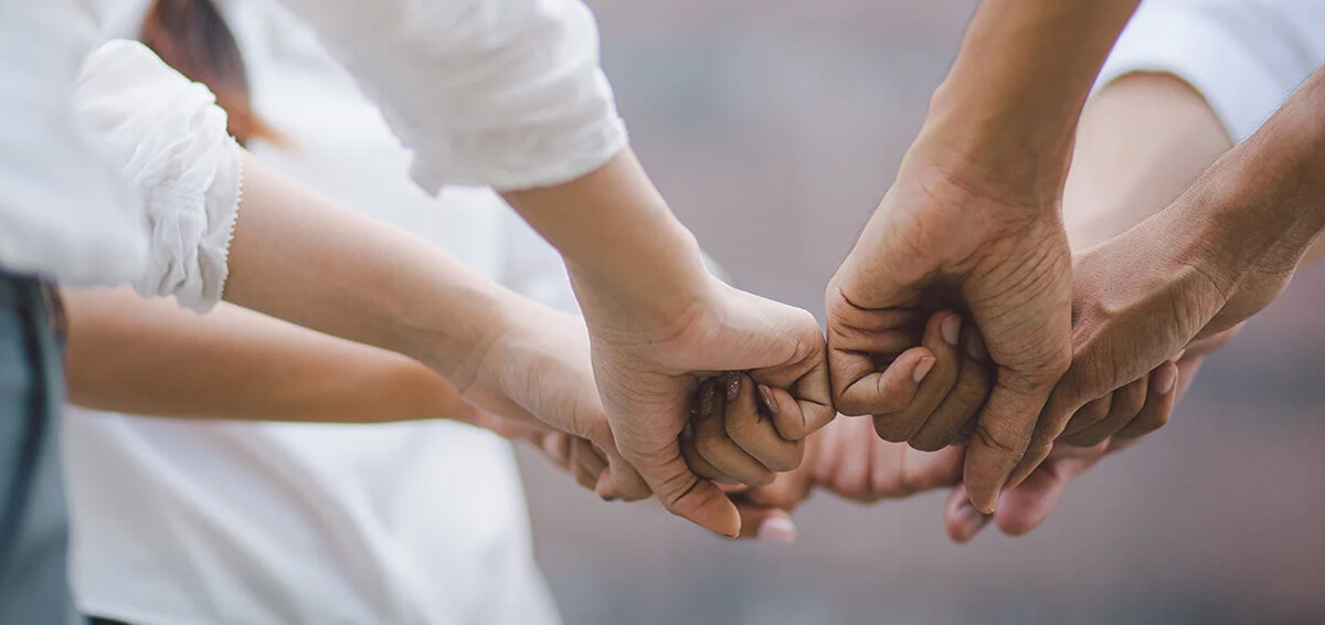 Several people joining their hands in the centre