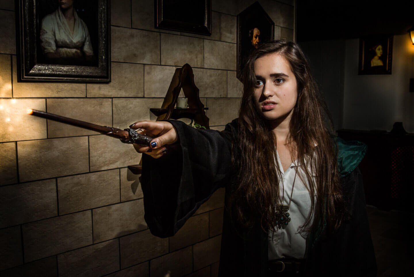 Witch holding out her wand in a magical escape room