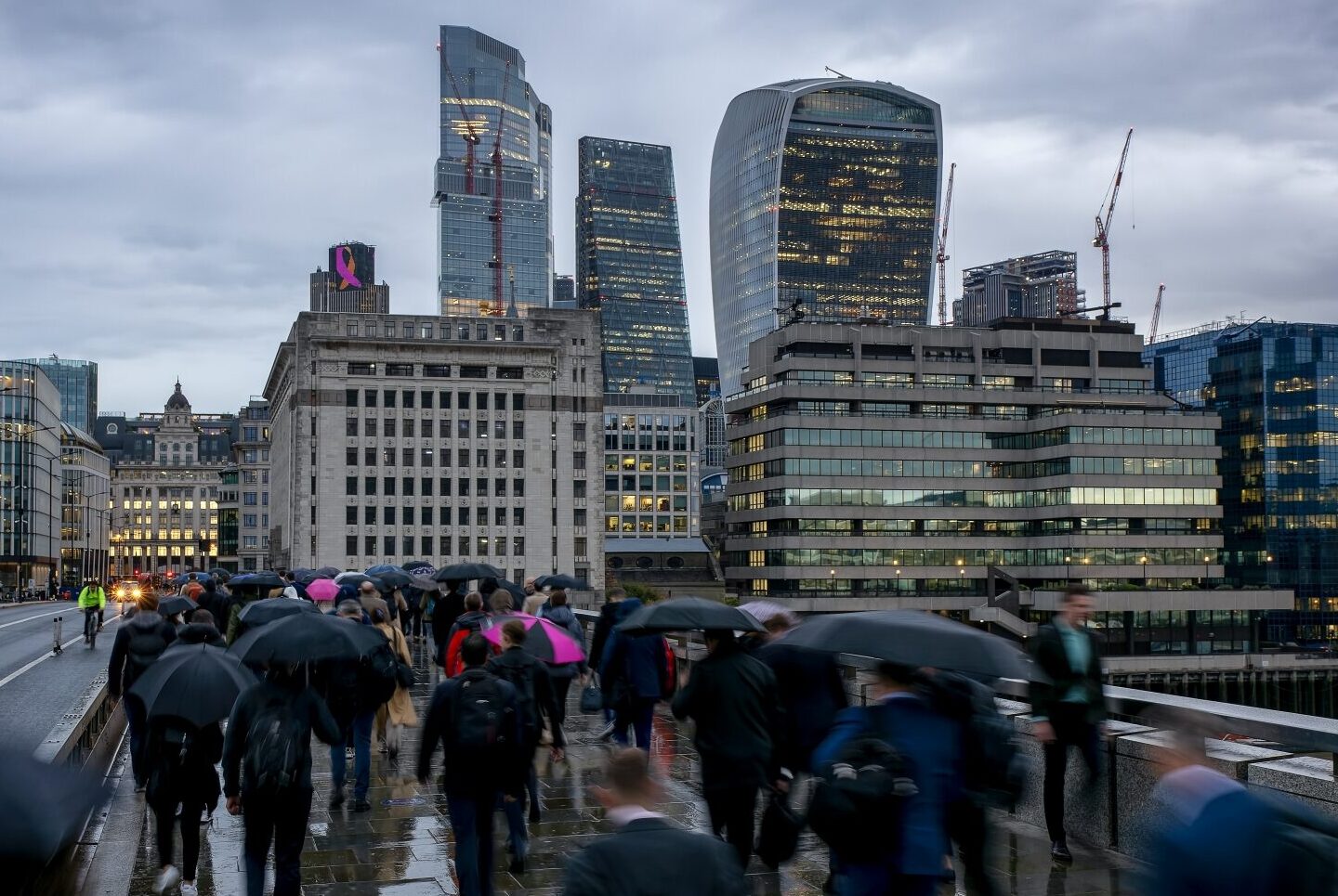 A bridge in London in the rain, with many people using umbrellas