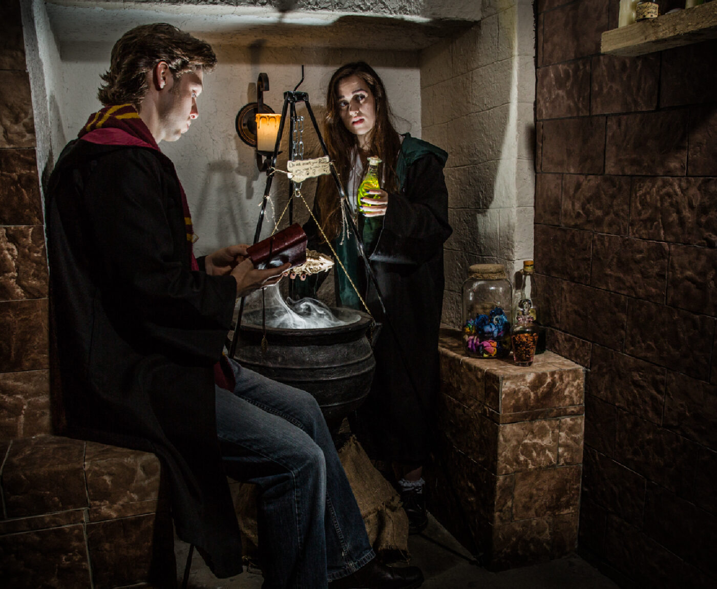 Man and woman in a magic escape room using a smoking cauldron